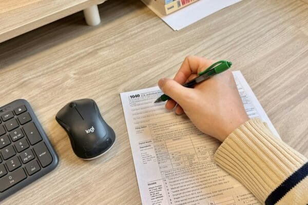 Student completing a competitive exam paper at a study desk