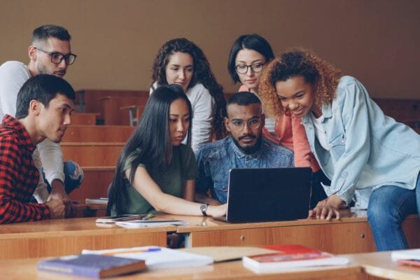 Students preparing together with books and laptop for competitive examinations