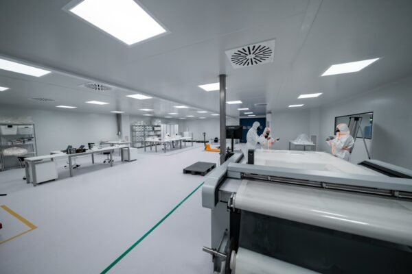 Technical operators working with precision equipment in a controlled engineering environment