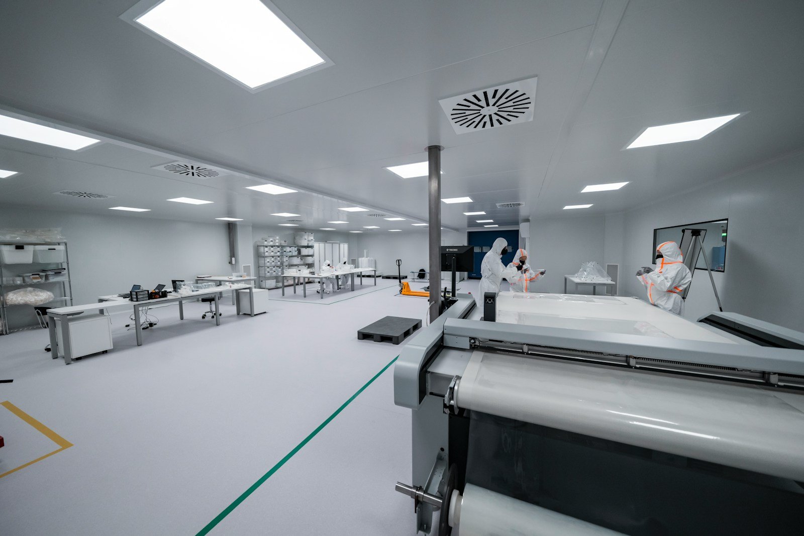 Technical operators working with precision equipment in a controlled engineering environment