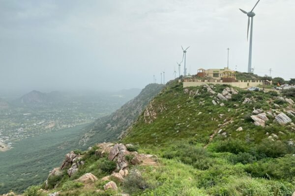 Wind turbine on a hill representing renewable energy and grid storage