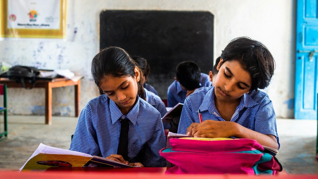 Candidates working at desks in a classroom setting for competitive examination