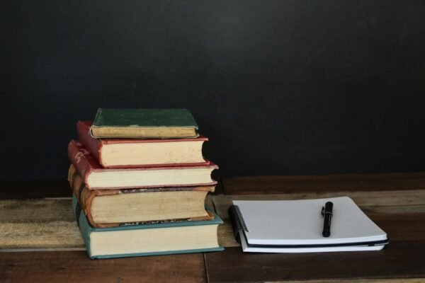 Books, paper and pen on a desk for competitive exam preparation and current affairs revision